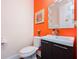 Stylish half bathroom with orange wall, modern sink, and elegant mirror at 1096 Holly Ave, Atlanta, GA 30338