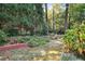 Tranquil backyard featuring a serene lawn bordered by trees, and a low brick wall at 3474 Castleridge Dr, Tucker, GA 30084
