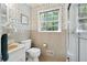 Well-lit bathroom features neutral tiling, a window with a leafy view, and a glass-enclosed shower at 3474 Castleridge Dr, Tucker, GA 30084