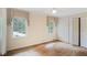 Well-lit bedroom with hardwood floors, two large windows, and a closet for storage at 3474 Castleridge Dr, Tucker, GA 30084