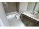 Bathroom features gray tiling, a shower-tub combo, and a vanity with dark wood finish at 634 Skytop Dr # 155, Cumming, GA 30040