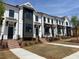 New townhouse exteriors feature white siding, dark accents, brick stairs and manicured lawns at 634 Skytop Dr # 155, Cumming, GA 30040