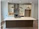 A kitchen features an island, pendant lighting, stainless steel appliances, and stylish range hood at 634 Skytop Dr # 155, Cumming, GA 30040