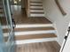 A home's white and wood staircase leads to the upper level, complemented by light-colored wood flooring at 634 Skytop Dr # 155, Cumming, GA 30040