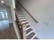 A bright stairway with wood handrail and white risers and trim connects the different levels of this home at 634 Skytop Dr # 155, Cumming, GA 30040