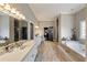Spacious bathroom features double vanities, soaking tub, and travertine flooring at 3720 River Mansion Dr, Peachtree Corners, GA 30096