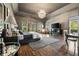 Spacious bedroom featuring a tray ceiling, chandelier, hardwood floors, and large windows at 3720 River Mansion Dr, Peachtree Corners, GA 30096