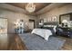 Bedroom featuring a tray ceiling, chandelier, hardwood floors, and patterned rug at 3720 River Mansion Dr, Peachtree Corners, GA 30096