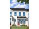 Close up of a charming new townhome with white siding, black trim, and covered front porch at 54 Black Gum Ln # 48, Auburn, GA 30011