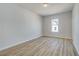 Bright bedroom features wood-look flooring, a window for natural light, and neutral walls, creating a serene space at 608 Marimba Pike, Mcdonough, GA 30253