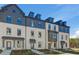 Wide angle view of townhomes featuring neutral brick and dark trim, as well as meticulous landscaping that creates a welcoming atmosphere at 608 Marimba Pike, Mcdonough, GA 30253