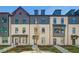 View of townhomes with neutral brick, black trim, and meticulously maintained landscaping offering an inviting curb appeal at 608 Marimba Pike, Mcdonough, GA 30253