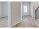 View of entry featuring hardwood flooring, natural light, and staircase with dark wood railing at 608 Marimba Pike, Mcdonough, GA 30253