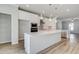 Modern kitchen with white cabinets, stainless steel appliances, and center island with unique globe lighting at 608 Marimba Pike, Mcdonough, GA 30253