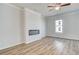 Open living room area has a modern fireplace and ceiling fan, with natural light from the windows at 608 Marimba Pike, Mcdonough, GA 30253