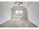 Spacious main bedroom featuring wood-look flooring, tray ceiling, and two windows that provide natural light at 608 Marimba Pike, Mcdonough, GA 30253