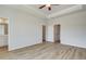 Spacious main bedroom showcasing wood-look flooring, tray ceiling, and doors to a bathroom and closet at 608 Marimba Pike, Mcdonough, GA 30253