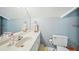 Powder blue bathroom features a single sink vanity with a large mirror and nearby toilet at 1260 Centenary Rdg, Snellville, GA 30078