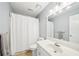 Bright bathroom features a single sink vanity, white shower curtain and ceramic tile at 1260 Centenary Rdg, Snellville, GA 30078