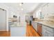 Bright kitchen features white cabinets, stainless steel appliances, and an island with granite countertops at 1260 Centenary Rdg, Snellville, GA 30078