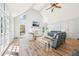 A cozy living room with vaulted ceilings, a brick fireplace, several windows with natural light, and wood flooring at 1260 Centenary Rdg, Snellville, GA 30078