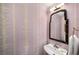 Well-lit powder room featuring stylish wallpaper, decorative mirror and basin sink at 2260 Peachtree Nw Rd # D6, Atlanta, GA 30309