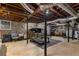 Unfinished basement featuring exposed beams, stone walls, and gym equipment for fitness enthusiasts at 26 Standish Nw Ave, Atlanta, GA 30309