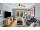 Bright living room features a ceiling fan, gray sofa, and French doors to an outdoor deck at 26 Standish Nw Ave, Atlanta, GA 30309