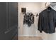 Organized walk-in closet with metal shelving, hanging clothes, and a dark gray paneled door at 612 Marimba Pike, Mcdonough, GA 30253
