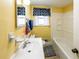 Cozy yellow bathroom featuring a white vanity, tub and patterned accents at 6348 Garnet Dr, Douglasville, GA 30135