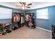Bedroom with light blue walls, two windows, ceiling fan, closet racks and shelves at 6348 Garnet Dr, Douglasville, GA 30135