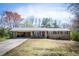 Charming brick ranch with a carport, a well-manicured lawn, and a welcoming front entrance at 6348 Garnet Dr, Douglasville, GA 30135