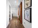 Hallway with wood floors, natural lighting and contemporary art at 1395 Windance Lake Dr, Loganville, GA 30052