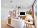 Bright living room with modern furniture, decorative leaves, ceiling fan, and hardwood floors at 1395 Windance Lake Dr, Loganville, GA 30052