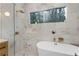 Bathroom featuring modern tub and walk-in shower, with marble tiling at 3306 Sleepy Se Ln, Smyrna, GA 30080