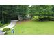 Traditional two-story home nestled among trees features a large front yard and long driveway at 3306 Sleepy Se Ln, Smyrna, GA 30080