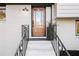 Inviting front entrance featuring a light wood door, white brick exterior, and wrought iron railings at 3306 Sleepy Se Ln, Smyrna, GA 30080