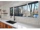 Bright kitchen with white countertops, wood cabinets, and a window overlooking the yard at 3306 Sleepy Se Ln, Smyrna, GA 30080