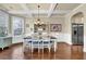 Formal dining room featuring hardwood floors, wainscoting, coffered ceiling, modern chandelier, and stainless steel refrigerator at 4315 Balsam Bark Dr, Cumming, GA 30028