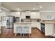 Spacious kitchen featuring an island with seating, stainless steel appliances, granite countertops, and hardwood floors at 4315 Balsam Bark Dr, Cumming, GA 30028