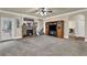 Carpeted living room with a stone fireplace, ceiling fan, and large built in entertainment center at 4315 Balsam Bark Dr, Cumming, GA 30028