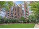 Beautiful red brick condo building with lush green lawn, trees, and landscaping at 1820 Peachtree Nw St # 608, Atlanta, GA 30309
