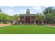 Elegant brick clubhouse surrounded by a lush green lawn with trees, columns, and planters at 1820 Peachtree Nw St # 608, Atlanta, GA 30309