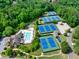 Aerial view of community tennis courts, pools, clubhouse, and playground surrounded by lush greenery at 2335 Flat Stone Dr, Cumming, GA 30041