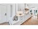 Well-lit kitchen has ample storage, stainless appliances, marble backsplash, adjacent mudroom with storage and seating at 2335 Flat Stone Dr, Cumming, GA 30041