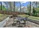 Outdoor seating area featuring a stone patio with a metal table and chairs, ideal for backyard gatherings and relaxing at 7040 Shady Oak Ln, Cumming, GA 30040