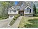 Charming home featuring a two-car garage and stone-accented entryway for added curb appeal at 7040 Shady Oak Ln, Cumming, GA 30040