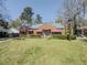 Charming brick home featuring a well-manicured lawn, mature trees, and red awnings at 1368 Scott Blvd, Decatur, GA 30030