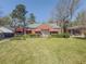 Charming brick home featuring a well-manicured lawn, mature trees, and red awnings at 1368 Scott Blvd, Decatur, GA 30030
