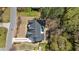 Aerial view of a home with a dark roof, a sparkling pool, a long driveway, and mature landscaping at 312 Meadow Dr, Alpharetta, GA 30009